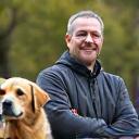 Portrait of Mark Jenkins, a dog trainer with a calm dog